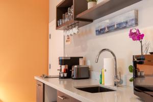 uma cozinha com um balcão com um lavatório em Oceanside Hotel and Suites em Miami Beach