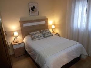 a bedroom with a large bed with two lamps on tables at Casa Anita in Luarca