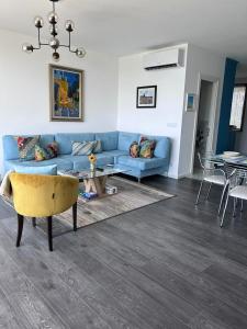 a living room with a blue couch and a table at Duplex Seaview Condo in Durrës