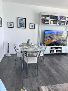 a dining room with a table with chairs and a tv at Duplex Seaview Condo in Durrës