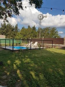 a fence with a pool and a windmill at Residencial Las Lechuzas in Villa Anizacate