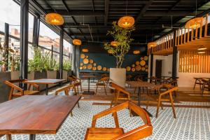 a restaurant with wooden tables and chairs and windows at Liv Hotels in Bogotá