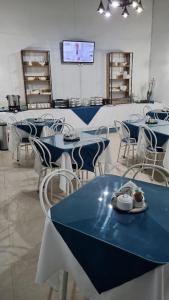 uma sala de jantar com mesas azuis e cadeiras brancas em ICCE HOTEL em Santiago