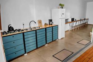 a kitchen with blue cabinets and a white refrigerator at Pousada Silvestre in Tramandaí