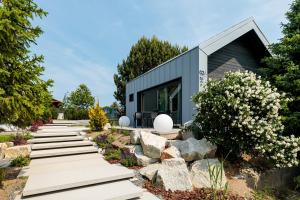 a modern house with a stone walkway in a garden at SKARPA resort in Ustronie Morskie