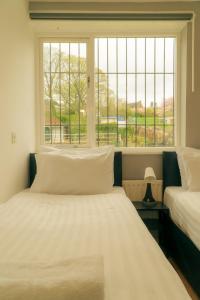 two beds in a room with a window at Great offers on Long Stays!! LaLuNa Apartments in Gateshead