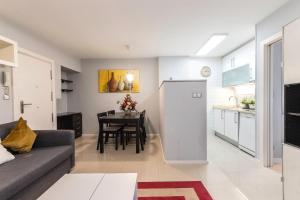 cocina y sala de estar con sofá y mesa en Apartamento en centro de Bilbao, Deusto, en Bilbao
