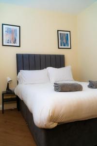 a bedroom with a large bed with white sheets and pillows at Great offers on Long Stays!! LaLuNa Apartments in Gateshead