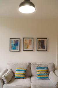 a living room with a couch and two pictures on the wall at Great offers on Long Stays!! LaLuNa Apartments in Gateshead