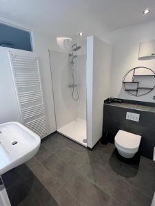 a bathroom with a sink and a toilet and a shower at UNiQE I Stilvolle 115qm I Terrasse I BBQ in Feldafing