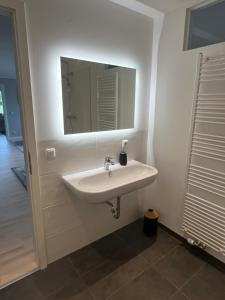 a white sink in a bathroom with a mirror at UNiQE I Stilvolle 115qm I Terrasse I BBQ in Feldafing