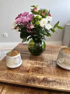 um vaso de flores sentado numa mesa de madeira em UNiQE I Stilvolle 115qm I Terrasse I BBQ em Feldafing