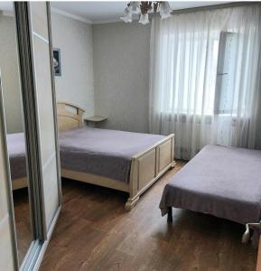 1 dormitorio con 2 camas y un espejo grande en Апартаменты, 2 комн. 6 мест, en Kropyvnytskyi