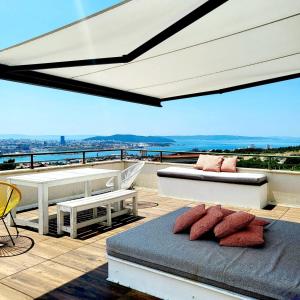 balcón con sofá, mesa y sillas en Holiday house in Split with sea view, terrace, air conditioning, WiFi 4937-1, en Solin