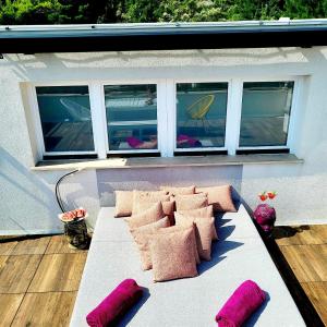 un sofá sentado en un porche con almohadas rosas en Holiday house in Split with sea view, terrace, air conditioning, WiFi 4937-1, en Solin