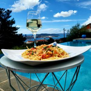 un plato de pasta con una copa de vino en Holiday house in Split with sea view, terrace, air conditioning, WiFi 4937-1, en Solin