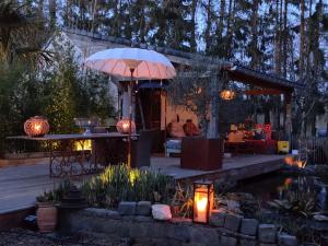 een patio met een parasol en een vijver bij De Tuinkamer in Lanaken