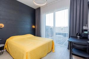 ein Schlafzimmer mit einem gelben Bett und einem Fenster in der Unterkunft 2NIGHT in Šventoji in Palanga