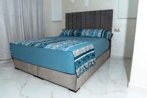 a bed in a white room with blue sheets and pillows at A&R Apartment Nador Jadid Hay Al Matar ,Klimatisiert,Air-Conditioned in Nador
