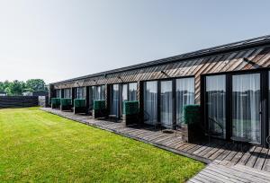 eine Reihe von Fenstern auf einem Gebäude mit grünem Gras in der Unterkunft 2NIGHT in Šventoji in Palanga