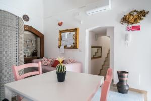 comedor con mesa blanca y sillas rosas en Il Borgo Antico B & B, en Capurso