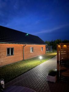 Una casa con una luz en el costado. en Domki Arkadia Mielno, en Mielno