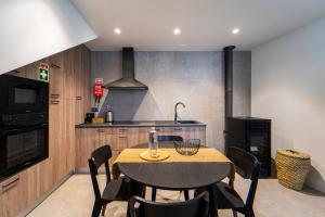 uma cozinha com uma mesa com cadeiras e um fogão em Maria Veiga Guest House em Viana do Castelo