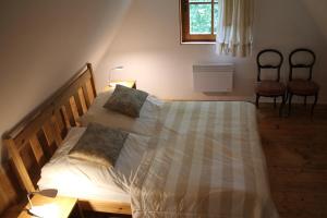 ナウェンチュフにあるDom w Jaśminachのベッドルーム1室(ベッド1台、椅子2脚、窓付)