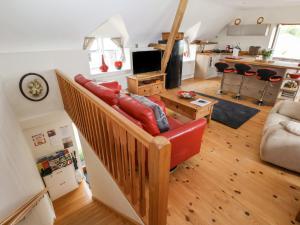 a living room with a couch and a kitchen at Coach House in Ruthin