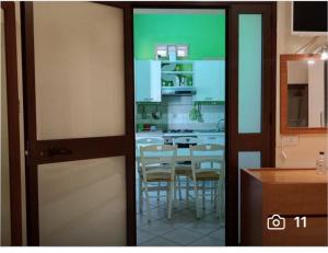 una cocina con armarios blancos y una mesa con sillas. en La Casetta Nell' Atrio Cavalieri, en Bagheria