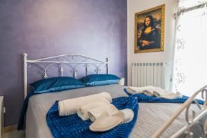 a bedroom with two beds with towels and a painting at Il Borgo Antico B & B in Capurso