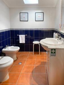 uma casa de banho com 2 lavatórios e um WC em Casa do Pelourinho em Belmonte