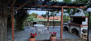 a patio with a table and chairs and a fireplace at Artist's House in Ierissos