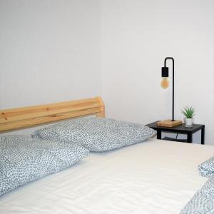 a bed with two pillows and a lamp on a table at Vikendica Farah in Gaj +43 photos
