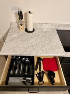 un tiroir avec ciseaux et autres ustensiles de cuisine sur un comptoir dans l'établissement Cozy Adventure Casita, à Saint George