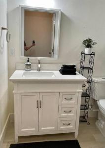 a white bathroom with a sink and a mirror at Cozy Adventure Casita in St. George