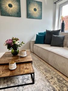 uma sala de estar com um sofá e uma mesa em UNiQE I Stilvolle 115qm I Terrasse I BBQ em Feldafing