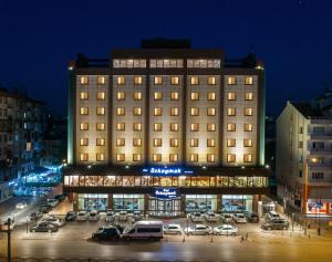 a large building with cars parked in a parking lot at Ozkaymak Konya Hotel in Konya