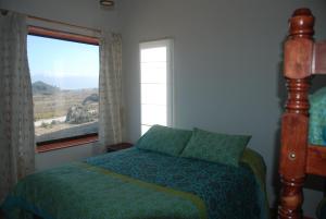 a bedroom with a bed and a window with a view at Cabanas Las Hualas in Punta de Choros