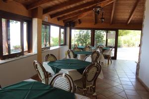 a restaurant with tables and chairs with green tablecloths at Villa Incanto B&B in Caprioli