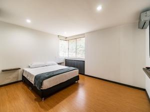 1 dormitorio con cama y ventana grande en APARTAMENTO EN ENVIGADO, en Envigado