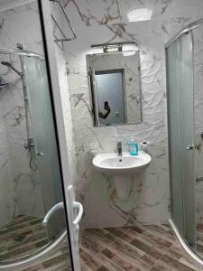 La salle de bains est pourvue d'un lavabo, d'une douche et d'un miroir. dans l'établissement бутиков апартамент Деси, à Pomorie