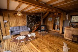 sala de estar con sofá y chimenea en Cabañas Borde Rio Las Trancas, en Nevados de Chillán