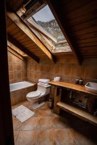 a bathroom with a toilet and a tub and a sink at Cabañas Borde Rio Las Trancas in Nevados de Chillan