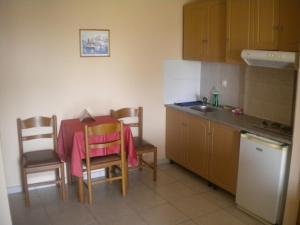 a kitchen with a table and chairs and a sink at Porto Lagos Rooms in Lágos