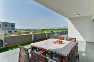 a dining table and chairs on a balcony with a view at LUXURY MARIJANA APARTMENT in Privlaka
