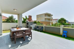 a patio with a table and chairs on a balcony at LUXURY MARIJANA APARTMENT in Privlaka