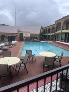 a view of a pool with tables and chairs at SureStay Hotel by Best Western Mt Pleasant in Mount Pleasant