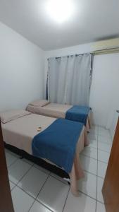 2 camas en una habitación con suelo blanco en APTO Cheio de Estilo, en São Luís