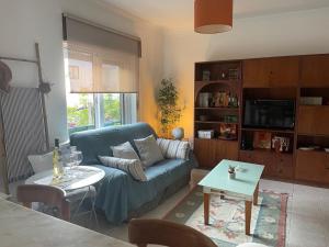 a living room with a blue couch and a table at BestHomeStay- Caparica Beach Lisbon in Almada